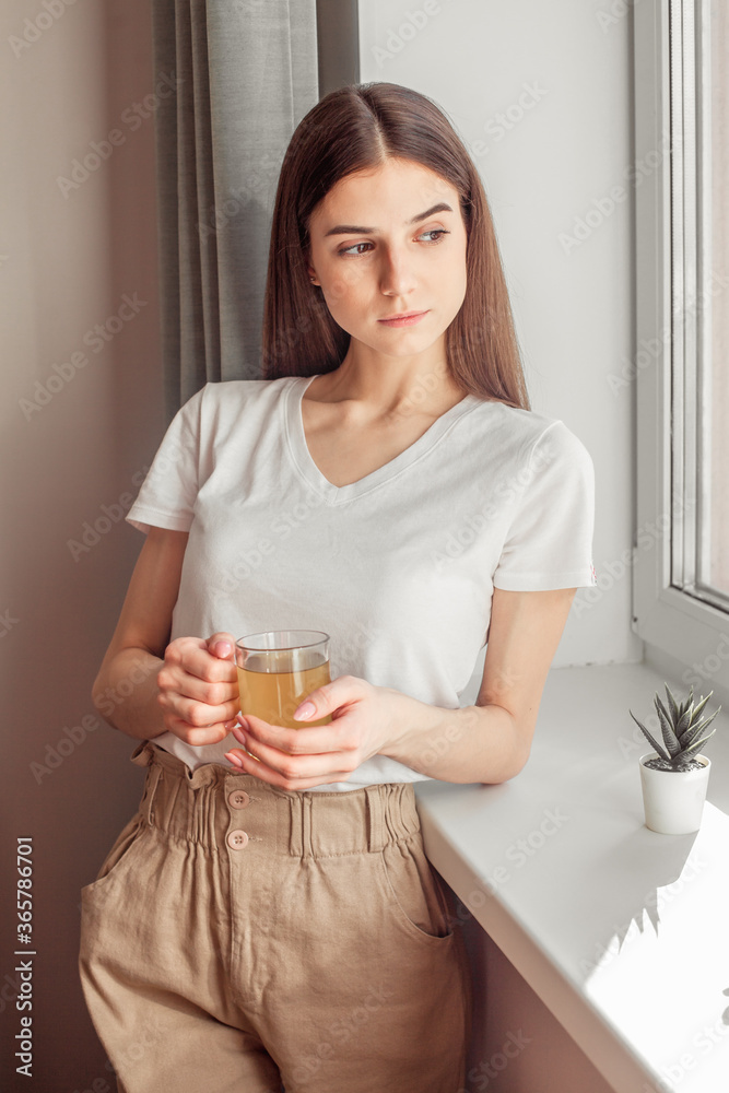 Beautiful woman drinking morning tea behind window Beautiful woman drinking morning tea behind window