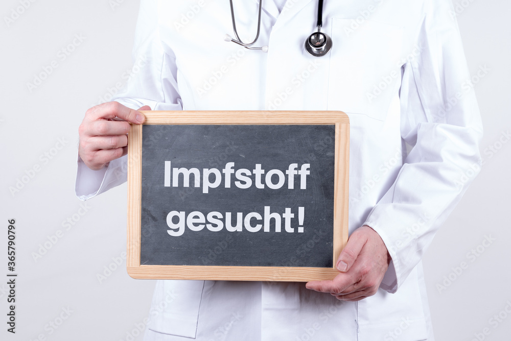Arzt mit einer Tafel auf der Impfstoff gesucht steht Arzt mit einer Tafel auf der Impfstoff gesucht steht