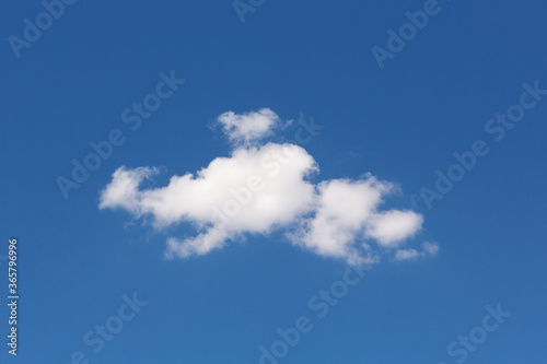 one white cloud of a bizarre shape  against a blue sky