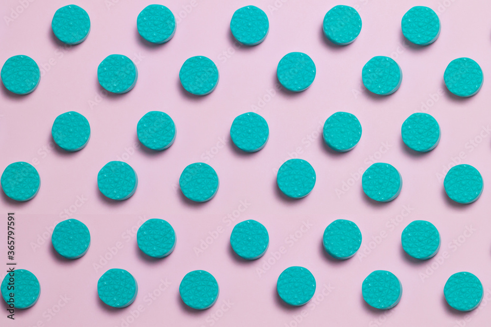 Numerous round and green tiles create a lines pattern on a pastel-colored background. Numerous round and green tiles create a lines pattern on a pastel-colored background.