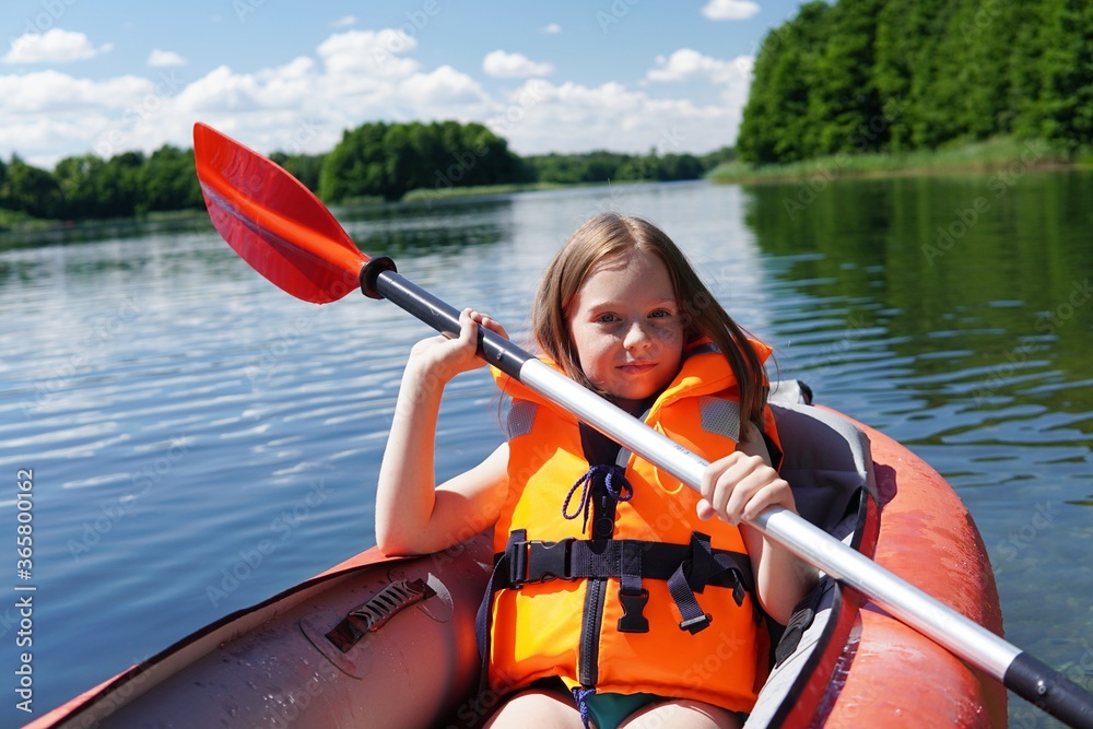 Teenage girl kayaking with inflatable kayak, summer vacation with kids,  leisure on lake, summer camp, family camping. Stock Photo