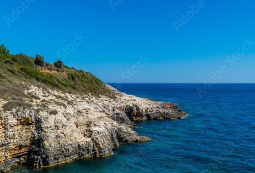 Beautiful rocky Cliffs with people on boats in Kamenjak National Park, Istria, Croatia