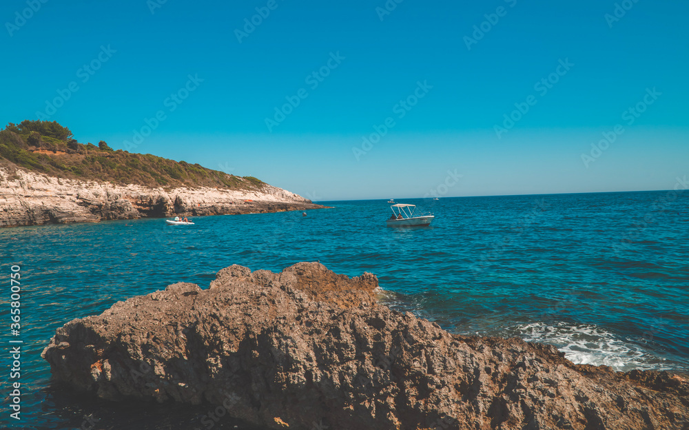 Panoramic afternoon view of beautiful rocky Cliffs with people on boats in Kamenjak National Park, Istria, Croatia