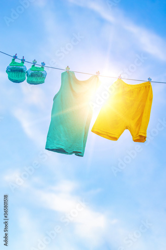 Homemade children's cloth slippers and clothes hung in the sun