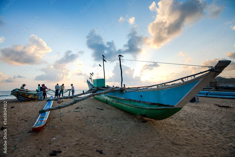 bateaux de pêche colorés ou pagode traditionnel au lever du jour sur une plage du sud de l'île de Ceylan, Sri Lanka
