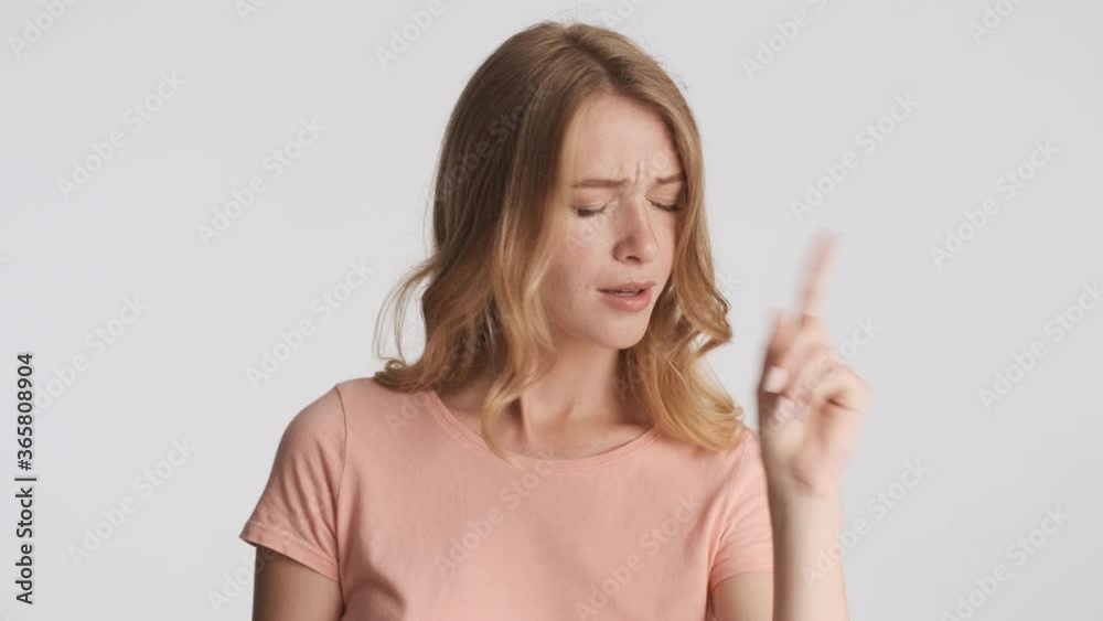 Beautiful emotional girl confidently showing no gesture and amazedly looking in camera over gray background Beautiful emotional girl confidently showing no gesture and amazedly looking in camera over gray background