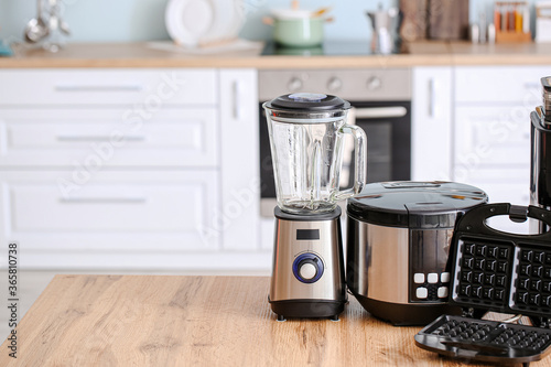 Different household appliances on table in kitchen photo