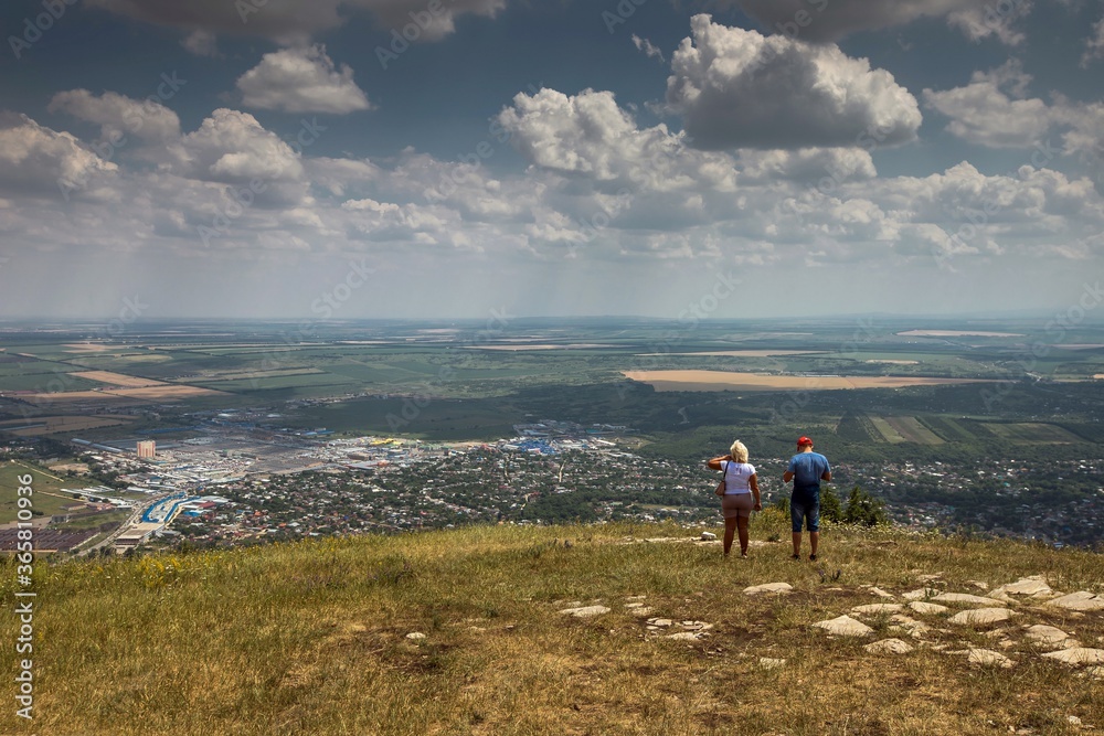 Obraz premium Two tourists enjoy the beautiful view of Pyatigorsk city from Mashuk mountain. Russia. Nice summer day.