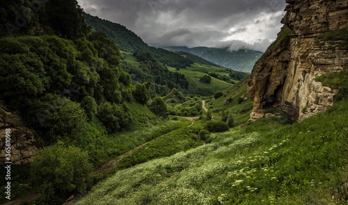 Beautiful green mauntain saddle Aktoprak in Kabardino-Balkariya, Russia. Summer green trees and road running between mountains.