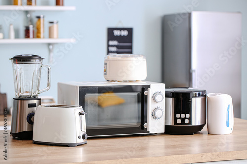 Different household appliances on table in kitchen photo
