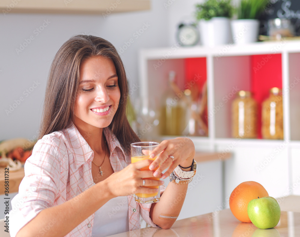 Young woman sitting a table in the kitchen. Young woman Young woman sitting a table in the kitchen. Young woman