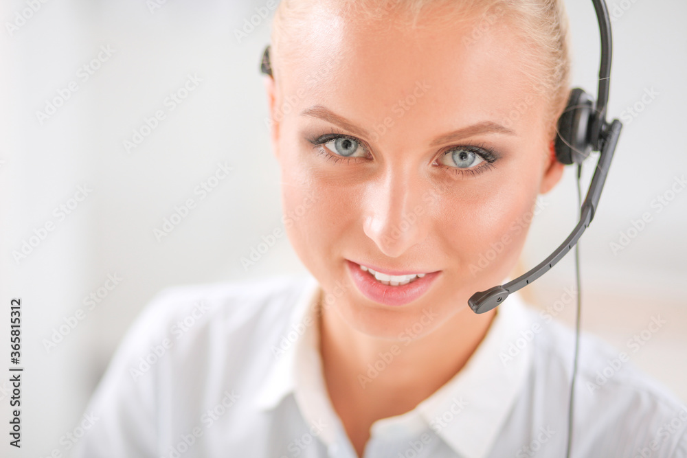 Portrait of pretty young female operator sitting at office desk with headset Portrait of pretty young female operator sitting at office desk with headset