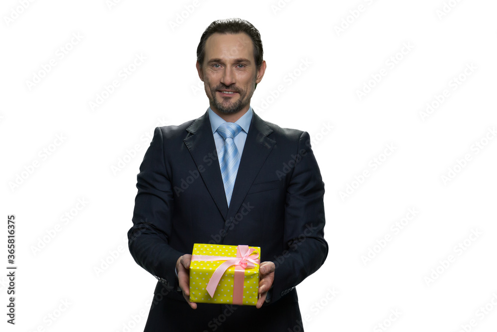 Mature man gives a present wrapped in yellow gift paper. Middle-aged businessman isolated on white background. Mature man gives a present wrapped in yellow gift paper. Middle-aged businessman isolated on white background.