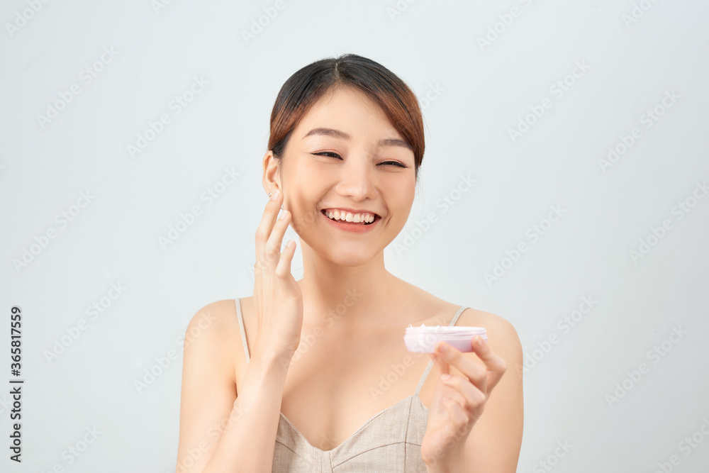 A beautiful asian woman using a natural skin care product, moisturizer or lotion. isolated with clipping path A beautiful asian woman using a natural skin care product, moisturizer or lotion. isolated with clipping path