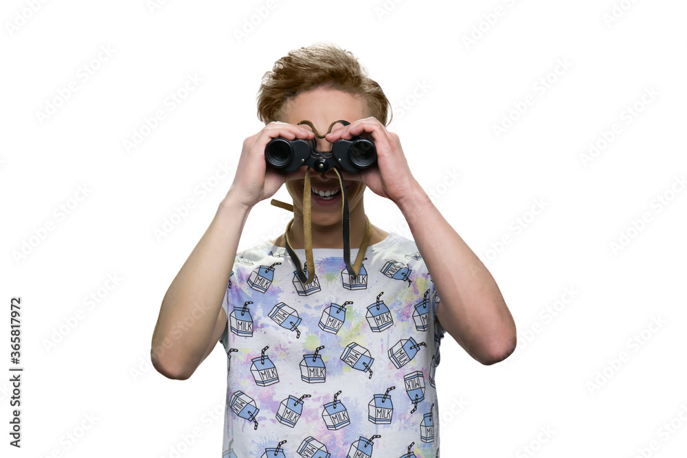 Smiling cheerful teenage boy is looking through binoculars. Isolated on white background. Smiling cheerful teenage boy is looking through binoculars. Isolated on white background.