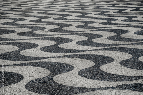 Typical portuguese cobblestone hand-made mosaic pavement, in Rossio Square or Pedro IV Square (Praça de D. Pedro IV), Lisbon, Portugal.