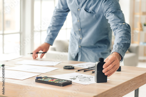 Senior male calligraphist working in office