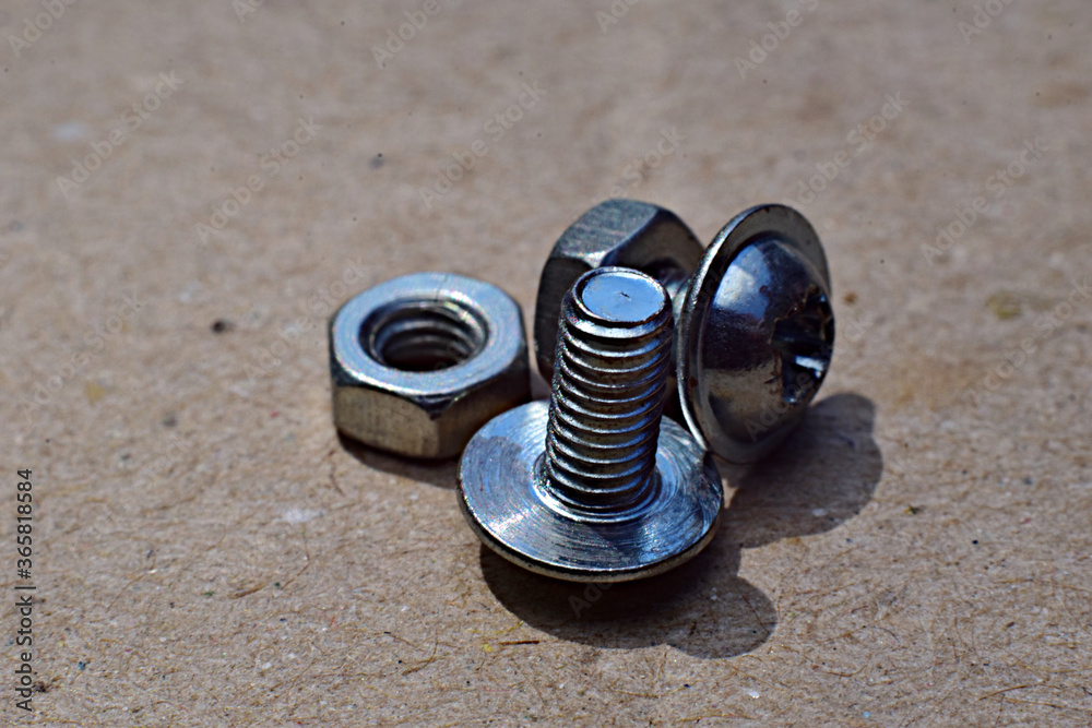 Small bolts and nuts on cardboard. Small bolts and nuts on cardboard.