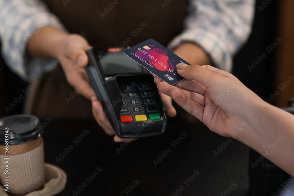 Customer paying for coffee via terminal in cafe, closeup Customer paying for coffee via terminal in cafe, closeup