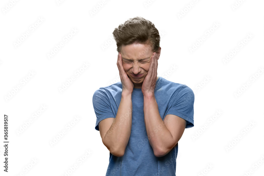 Portrait of teenager is suffering from terrible headache. Touching head with both hands. Isolated on white background. Portrait of teenager is suffering from terrible headache. Touching head with both hands. Isolated on white background.