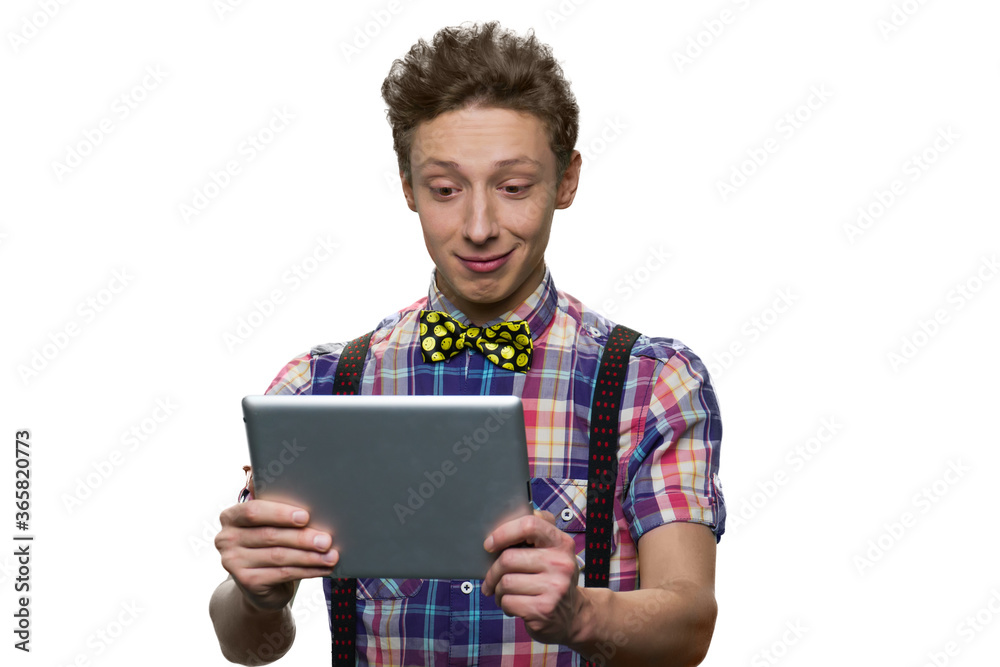 Teenage boy looking at tablet pc with facial expression of bewilderment. Isolated on white background. Teenage boy looking at tablet pc with facial expression of bewilderment. Isolated on white background.