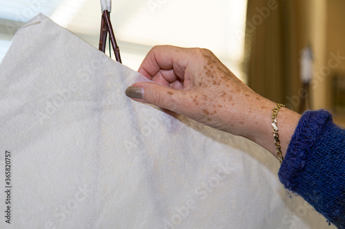 Elderly ladies hand is holding some paper - creating art  in a retirement home concept. photo