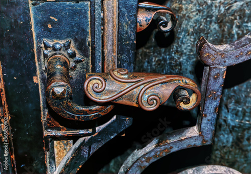 Old lock and rusty handle on natural wooden surface with rich texture.