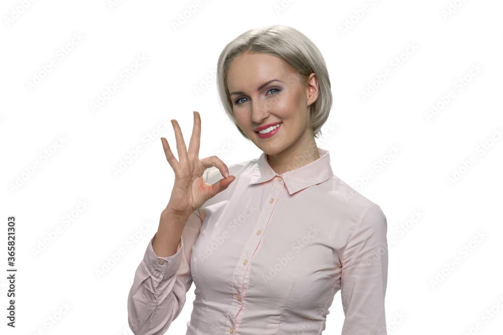 Mature blond woman is showing ok gesture. Middleaged european lady isolated on white. Mature blond woman is showing ok gesture. Middleaged european lady isolated on white.