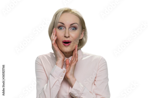 Portrait of amazed mature lady in formal shirt. Facial expression of surprise and shock. Happy blond businesswoman isolated on white.