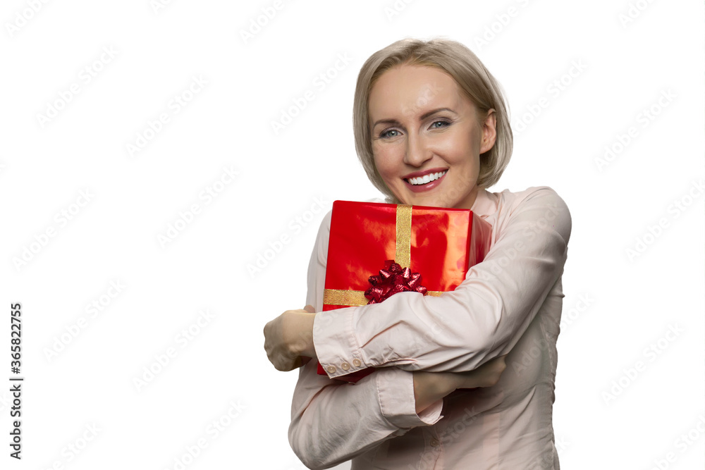Portrait of smiling woman holding in hands hugging celebratory gift box. Giftbox with gold ribbon. Portrait of smiling woman holding in hands hugging celebratory gift box. Giftbox with gold ribbon.