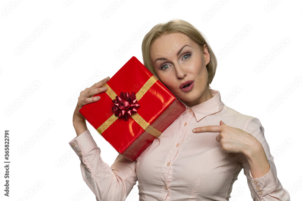 Portrait of nice attractive amazed girl with red gift present isolated white background. Suprised woman poiting at giftbox by finger. Portrait of nice attractive amazed girl with red gift present isolated white background. Suprised woman poiting at giftbox by finger.