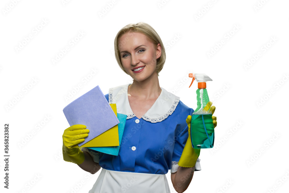 Happy young maid holding rag and spray on white background. House keeping concept. Happy young maid holding rag and spray on white background. House keeping concept.