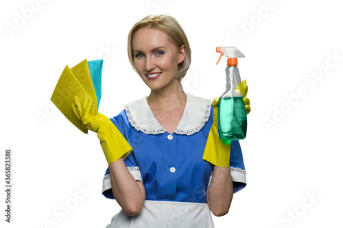 Smiling blonde maid holding rag and spray cleaner gun white background. House keeping concept