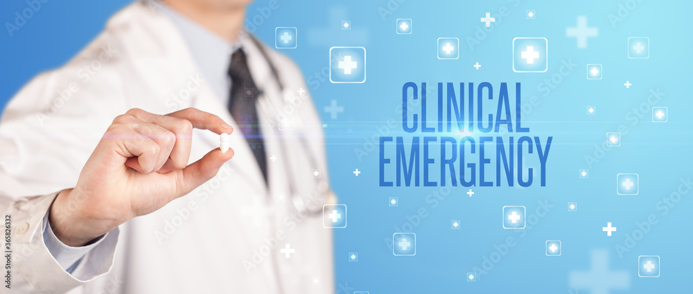 Close-up of a doctor giving a pill with CLINICAL EMERGENCY inscription, medical concept Close-up of a doctor giving a pill with CLINICAL EMERGENCY inscription, medical concept