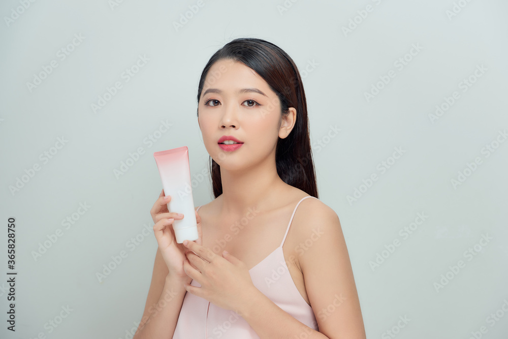 Beautiful Woman Face Portrait holding and presenting cream tube product Beautiful Woman Face Portrait holding and presenting cream tube product