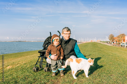 Man with toddler and cat on dyke