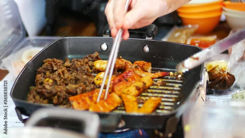 Person take cooking of meat with vegetable grill at home during pandemi. Family concept.