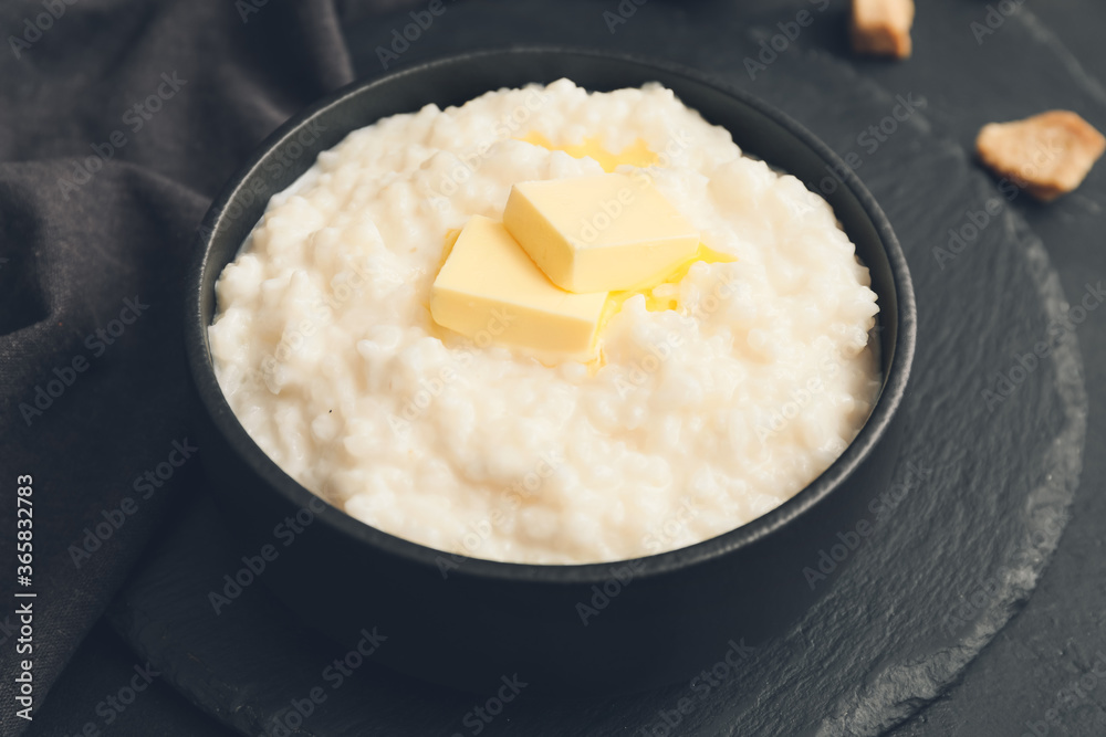 Bowl with boiled rice and butter on dark background Bowl with boiled rice and butter on dark background
