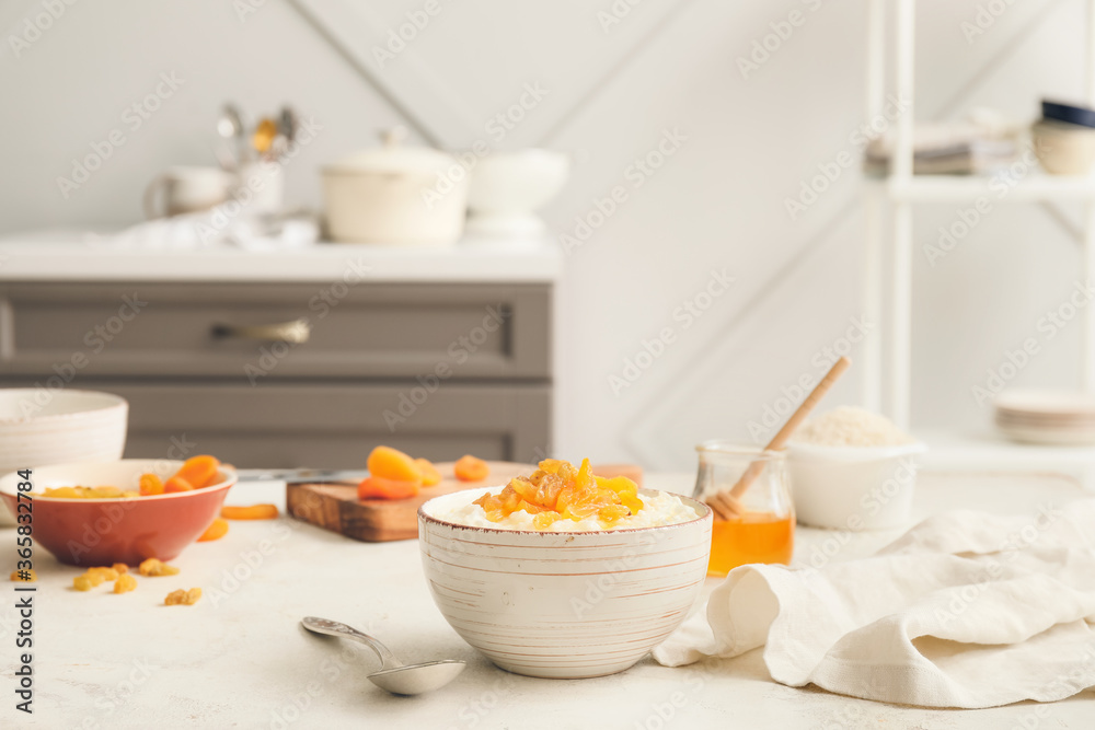 Bowl with boiled rice and fruits on table in kitchen Bowl with boiled rice and fruits on table in kitchen