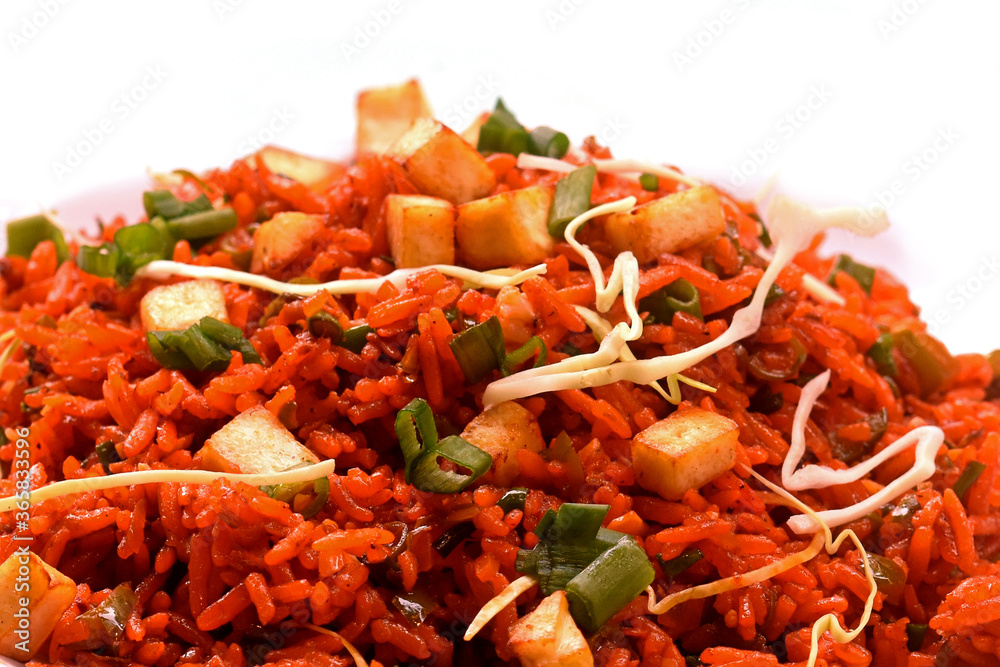 Schezwan paneer fried rice with schezwan sauce,Chinese fried rice with paneer,garnished with spring onion and cabbage