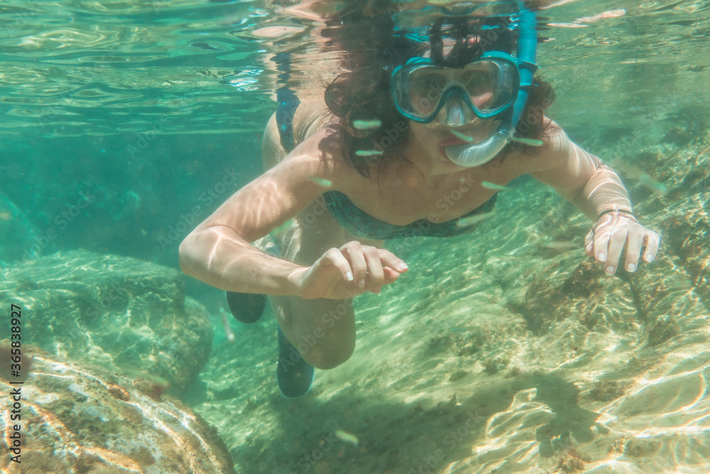 Naklejka premium Diving in a beautiful seabed in the town of Zarautz very close to San Sebastián, Gipuzkoa. Basque Country. A young woman diving on the seabed