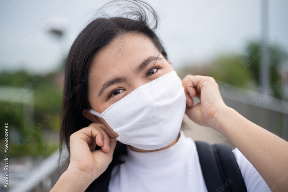 Asian woman happy smiling wearing protective face mask walking on overcrossing city street. New lifestyle with Corona Virus COVID-19. Asian woman happy smiling wearing protective face mask walking on overcrossing city street. New lifestyle with Corona Virus COVID-19.