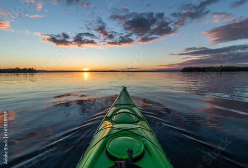 Kayaking at sunset on a calm lake in Northwest Ontario, Canada. photo