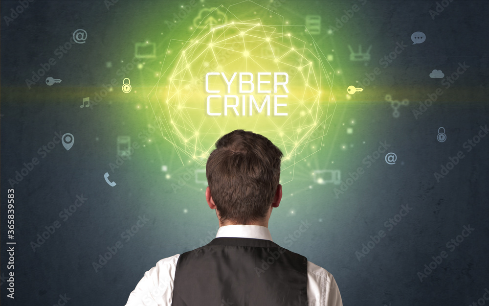 Rear view of a businessman with CYBER CRIME inscription, online security concept Rear view of a businessman with CYBER CRIME inscription, online security concept