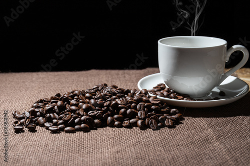 Coffee beans and a cup of coffee on a sackcloth