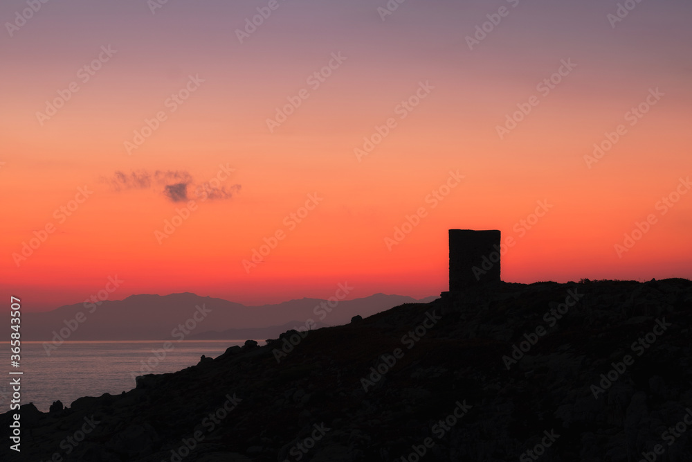 Dawn breaking behind genoese tower in Corsica