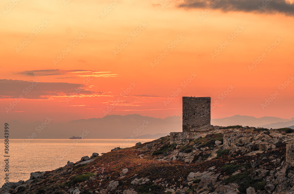 Dawn breaking behind genoese tower in Corsica Dawn breaking behind genoese tower in Corsica