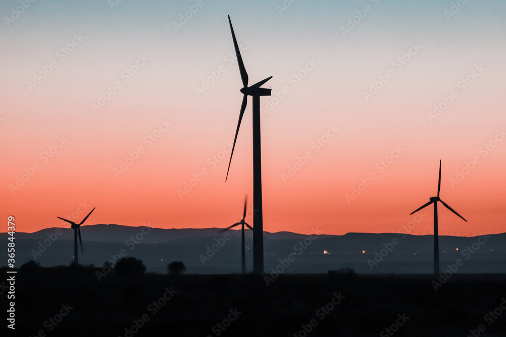 Blue hour with mills and renewable energy with mountains