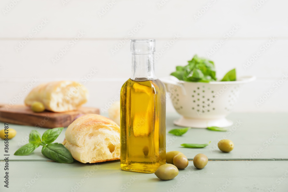 Bottle of tasty olive oil and bread on table Bottle of tasty olive oil and bread on table