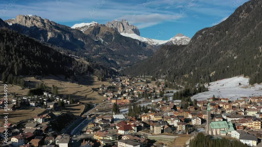Aerial drone flight above a mountain village Pozza di Fassa in the Dolomites, Alps, Italy. Beautiful nature of Italy. Dolomites winter lanscape Aerial drone flight above a mountain village Pozza di Fassa in the Dolomites, Alps, Italy. Beautiful nature of Italy. Dolomites winter lanscape